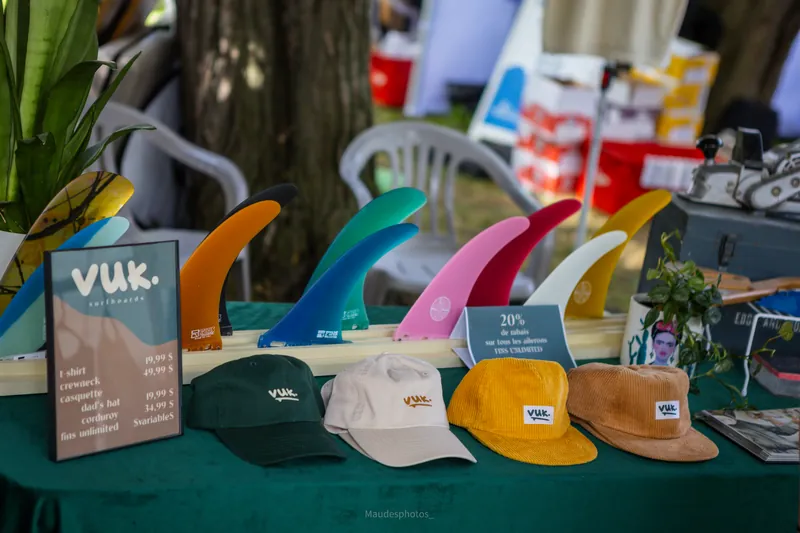 Des ailerons de surf colorés et des casquettes sur la table d'un kiosque